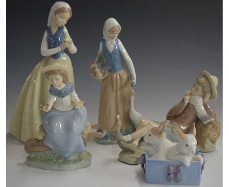 Lladro figure of a reclining boy and four Nao figures, tallest 27cm