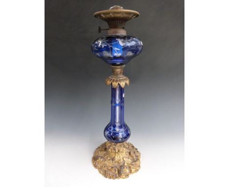 Victorian overlay cut glass oil lamp by Hinks and Sons Birmingham, the glass by Stevens and Williams. The ornate gilt base de