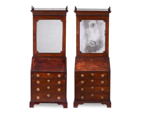 A PAIR OF GEORGE II MAHOGANY BUREAU BOOKCASESCIRCA 1750The mirror panel doors opening to adjustable shelves above two short d