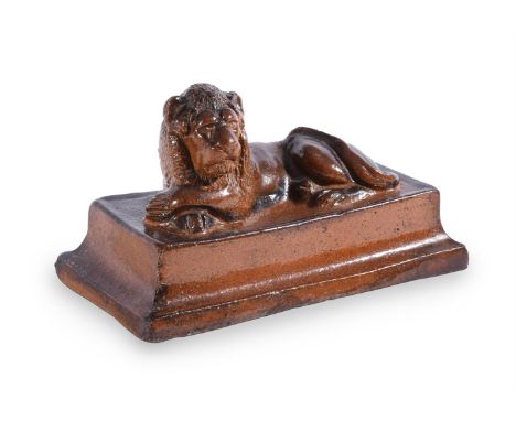 A SALT GLAZED STONEWARE MODEL OF A RECUMBENT LION ON A STEPPED BASE19TH CENTURY  14.5cm high, 26cm wide, 14cm deepCondition R