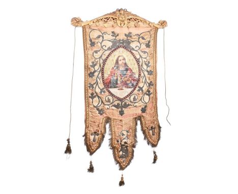 A SILK DAMASK AND METAL THREAD EMBROIDERED ECCLESIASTICAL PANEL WITH GILTWOOD CRESTMID 19TH CENTURY The panel centred with a 