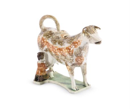 AN ENGLISH PEARLWARE MODEL OF A COW WITH MILKMAIDPOSSIBLY SOUTH YORKSHIRE, CIRCA 1820Sponge decorated in shades of brown and 