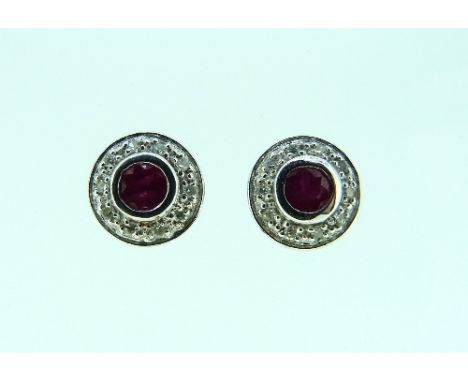 A pair of ruby and diamond Earrings, the central ruby collet set and with small diamond points around, all mounted in white g