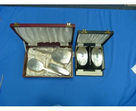 A cased pair of silver backed Hair Brushes and Comb Set, by Charles S. Green & Co Ltd., hallmarked Birmingham 1921, with engi