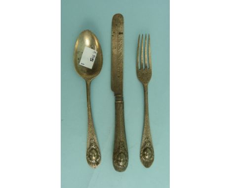 A Victorian silver three piece Knife, Fork and Spoon Set, hallmarked Sheffield, 1867, the handles chased with angelic masks a