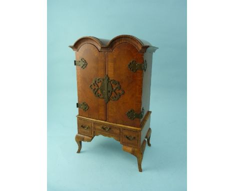 An early 20thC walnut Jewellery Cabinet, in the form of a Queen Anne style cupboard -on-stand, the pair of doors enclosing a 