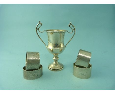 A George V silver two handled Trophy Cup, hallmarked Birmingham, 1930, 6in (5cm) high together with four various silver napki