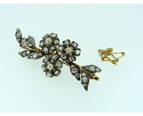 A diamond and pearl spray Brooch, formed of three diamond set flowers with pearl centres, on a branch of diamond set leaves, 