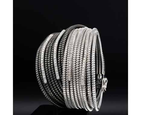 AN 18CT WHITE AND BLACK GOLD DIAMOND SET CUFF BANGLE, formed of eighteen spiral twist bands, with four bands each set with a 