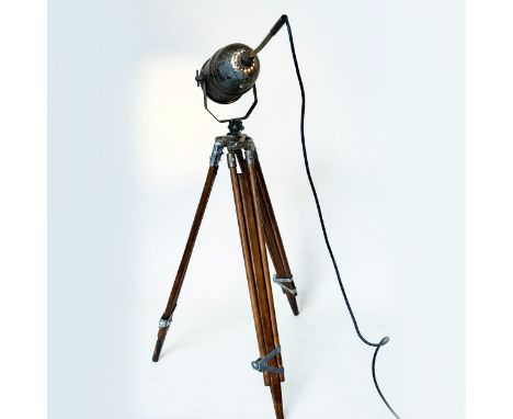 THEATRE LAMP, early 20th century spotlight mounted on an adjustable teak and nickel tripod, together with two similar tripods