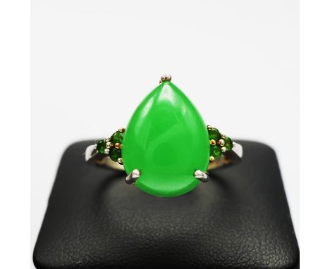 A STERLING SILVER JADE AND PERIDOT DRESS RING, the pear shaped jade cabochon flanked to each side by round cut peridots, spid