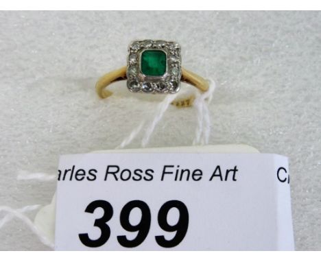 An emerald and diamond cluster ring, the step-cut cut cornered emerald within a band of single cut diamonds.   Condition Repo