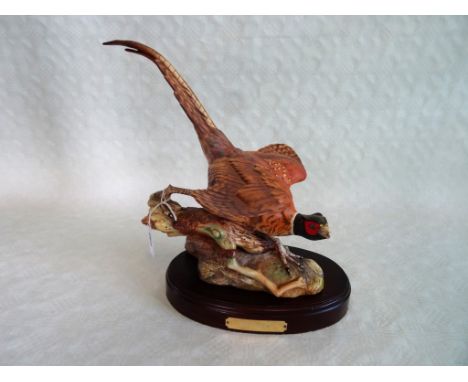 A large Beswick ceramic pheasant, perched on a log, mounted to an oval plinth, title 'Open Ground' printed marks to base, (th