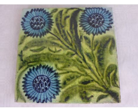 A William de Morgan tile, depicting three blue flowers amongst green leaves, impressed oval W de Morgan stamp to reverse (6 i