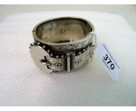 A Victorian silver buckle bangle, the wide bangle with decorative buckle and concealed push button side opening, foliate engr