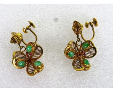 A pair of jade and ruby flower head pendant earrings, the gems set in basket worked petal structure and suspended from circul