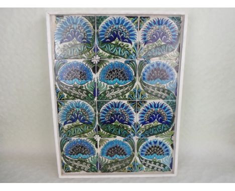 A William de Morgan Persian design tile panel, comprising twelve individual tiles painted in shades of blue and green, mounte