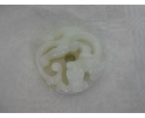 A pale Celadon jade carved dragon of circular form, with pierced central hole (5cm diameter).   Condition Report:  No apparen