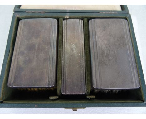A cased three pieced silver backed gentleman's brush set, having engine turned decoration, London hallmarks, 1946.