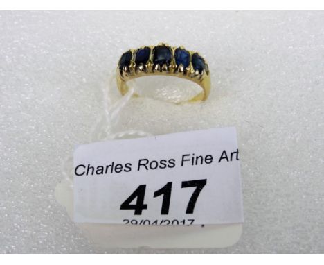 A five stone sapphire half-hoop ring, the graduated mixed cut stones in claw mounts to plain shank.