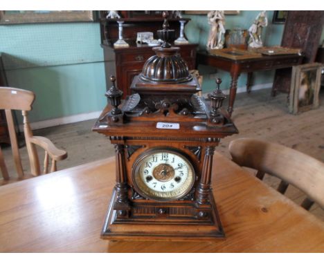 An oak cased mantle clock, the circular enamel chapter bearing Arabic numerals (46cm).