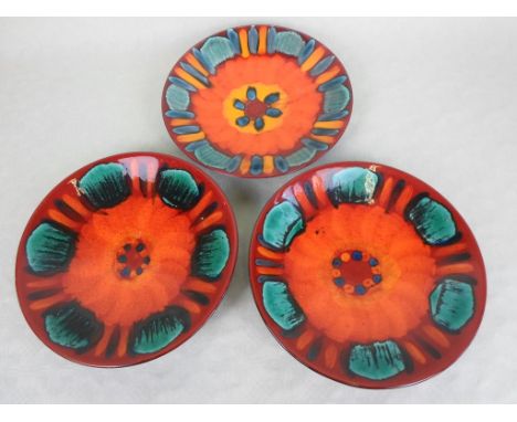 A collection of three Poole Pottery Volcano pattern dishes, each with printed marks and artist's monogram, two of them a pair