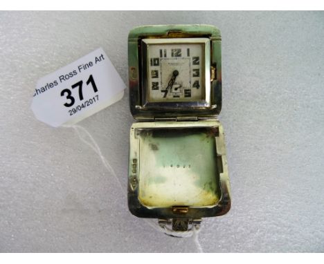An Edwardian silver and Guilloché enamel travelling clock, the cushion-shaped case with push button opening, to reveal a squa