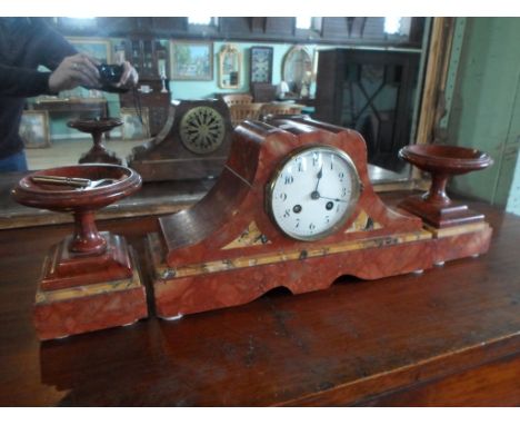 An Art Deco red marble clock garniture, the circular dial bearing Arabic numerals (34 x 11 x 18.5cm).
