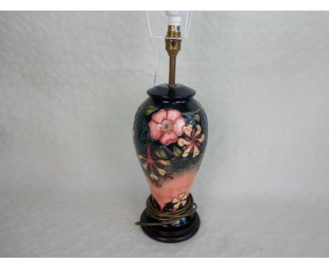 A contemporary Moorcroft ceramic baluster table lamp in the Oberon pattern by Rachel Bishop, mounted to a circular wooden sta