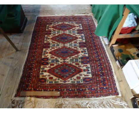 An Eastern carpet, the central field with four diamond lozenges on a mushroom ground, the border of repeating geometric desig