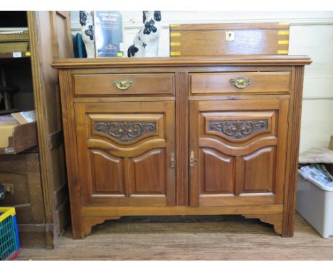 An Edwardian walnut sideboard, with two drawers over a pair of carved cupboard doors on bracket feet, 122cm wide