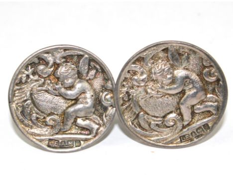 A pair of silver cufflinks depicting putti playing