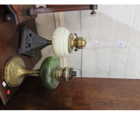 A brass and green glass oil lamp and a cast iron oil lamp (2)