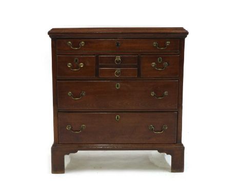 An unusual George III mahogany actor’s chest, the moulded rectangular top above an arrangement of seven drawers on bracket fe