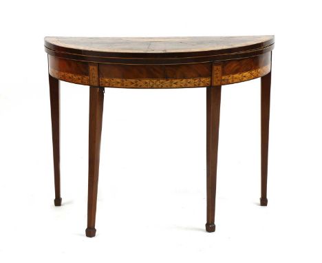 A George III mahogany satinwood demilune foldover card table, the segmented satinwood crossbanded top with foliate penwork de