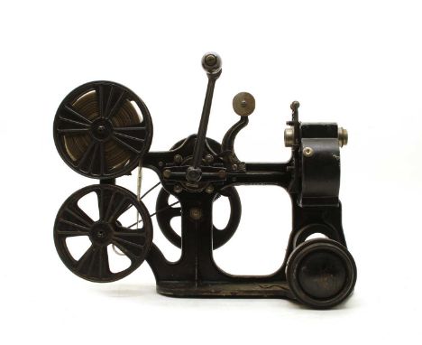 A Pathe Kok 28mm projector, French, early 20th century having cast black painted metal body with built in dynamo, 52.5cm wide