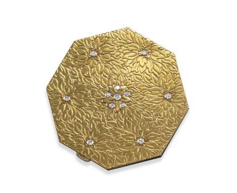An octagonal gold compact, with foliate decoration and circular-cut diamonds. Diamond-set thumbpiece and engine-turned decora