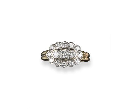 A diamond cluster ring, the three principal circular-cut diamonds are set within a surround of smaller circular-cut diamonds 