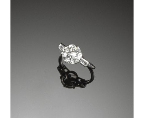 A diamond solitaire ring, the circular cut diamond weighs 2.55cts and is set with a baguette-shaped diamond to each shoulder 