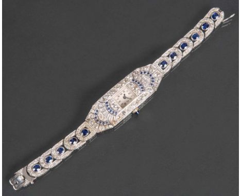 Art Déco-Damenarmbanduhr. Platin, ca. 33,0 g, besetzt mit Brillanten, ca. 6 - 7ct, elf Saphiren im Ovalschliff, 26 kleinen Sa