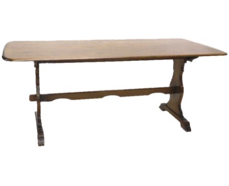 An Ercol style oak refectory type table, on end supports with a shaped stretcher, the top 84cm x 180cm.