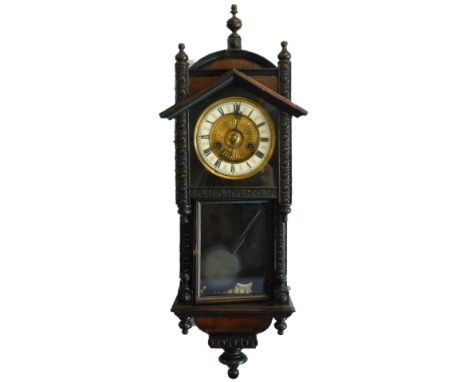 A late 19thC Continental mahogany drop dial wall clock, with enamel style Roman numerals, the case with carved decoration, 43