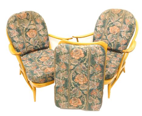 A pair of Ercol light stained beech cottage style open armchairs, and a matching stool. The upholstery is this lot does not c