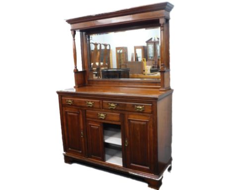 A Victorian walnut sideboard, the raised back with a bevelled rectangular plate, the base with an arrangement of three drawer