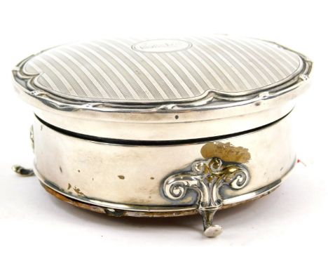 A George VI circular engine turned silver trinket box, the hinged lid enclosing a lined interior on shaped feet with oak base