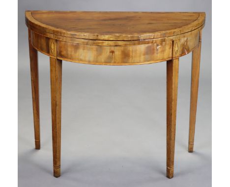 A late 18th/early 19th century inlaid mahogany demi-lune card table, inset green baize to the fold-over top, on square tapere