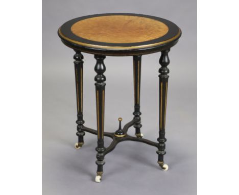 A Victorian ebonised and gilt-painted occasional table with amboyna-veneered circular top, on four fluted tapering turned leg