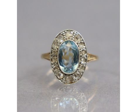 An early 20th century 18ct gold &amp; platinum ring set oval-cut aquamarine within a border of rose diamonds; size: J/K; 3gm.