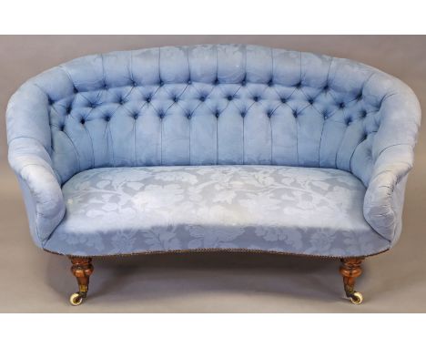 A Victorian simulated rosewood sofa with buttoned back, upholstered blue floral fabric, on short turned legs with ceramic cas