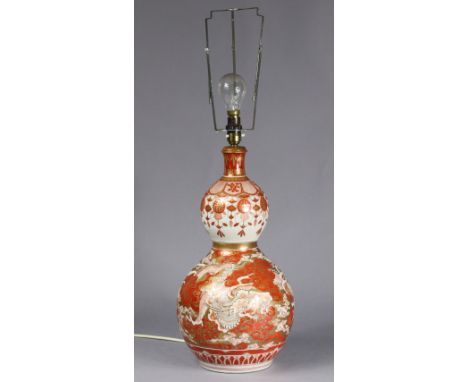 A late 19th century Japanese Kutani porcelain double-gourd vase forming a table lamp, decorated with mythical beasts chasing 